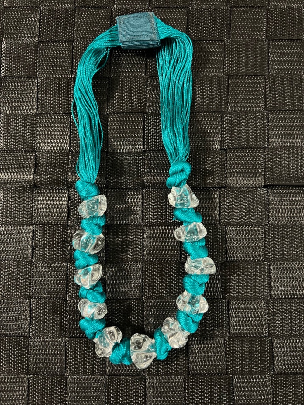 Hand made clear murano glass beads necklace hand knotted onto a turquoise cord.